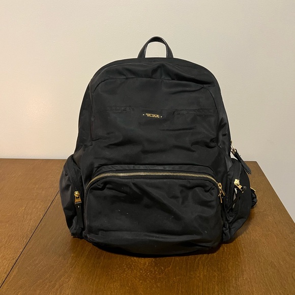 black tumi backpack with gold details Voyageur Atlanta ShopCGX resistant water bottle pocket that can be accessed from both in and outside the bag What's in #NellyKorda's Celina Backpack?